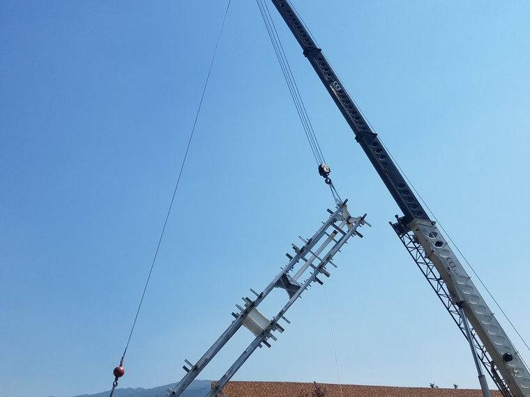 Crane setting a monopole section during erection