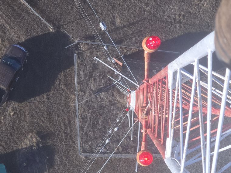 View down a guyed tower past the obstruction beacons to the compound below