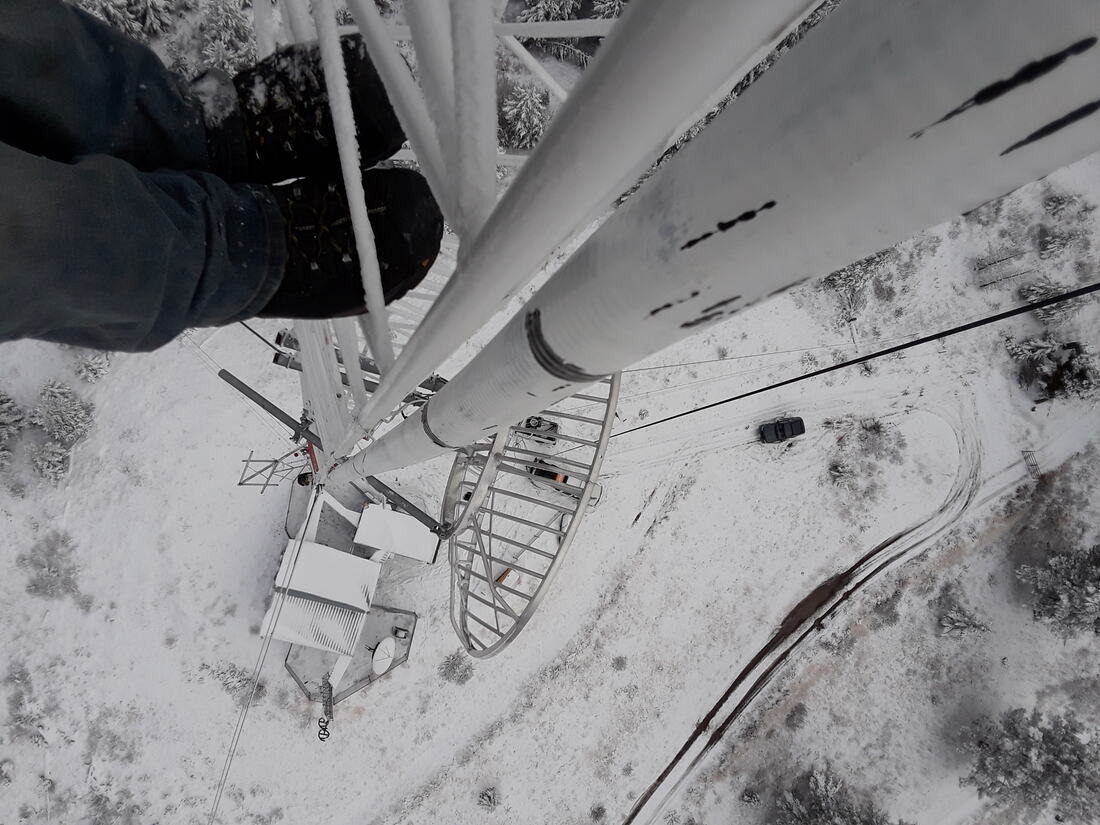 View straight down a snow-dusted monopole to the compound below